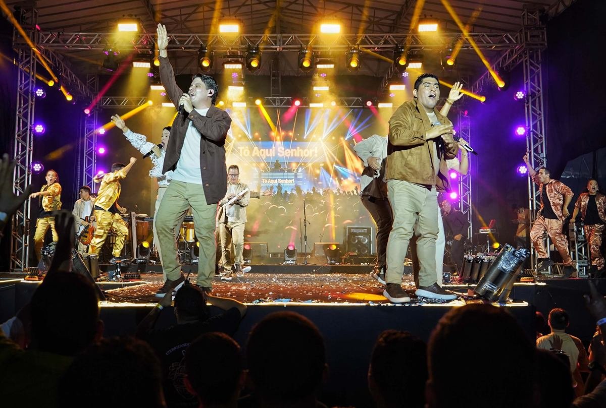Ministério de música católico se apresentando em um palco iluminado